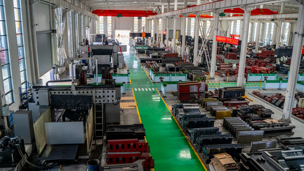 CNC machining workshop with rows of machining centres producing cast housings and valve parts