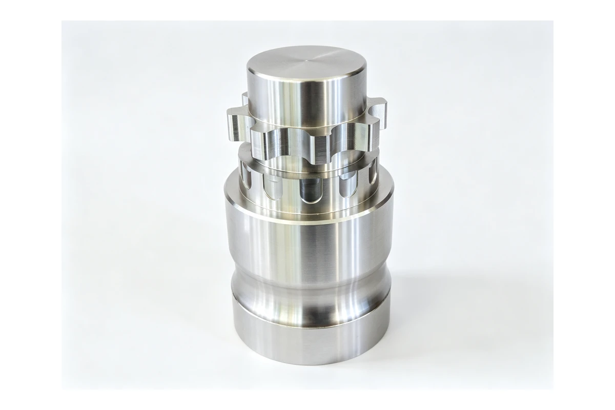 Machined steel coupling hub with a toothed flange face, a through bore and mounting holes, of the type used in a jaw type flexible coupling