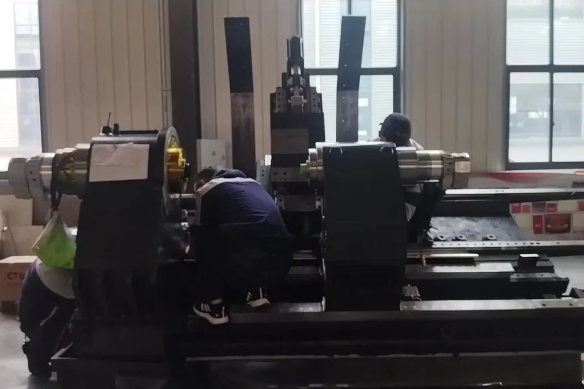 Large CNC lathe being assembled and aligned on the shop floor before shipment