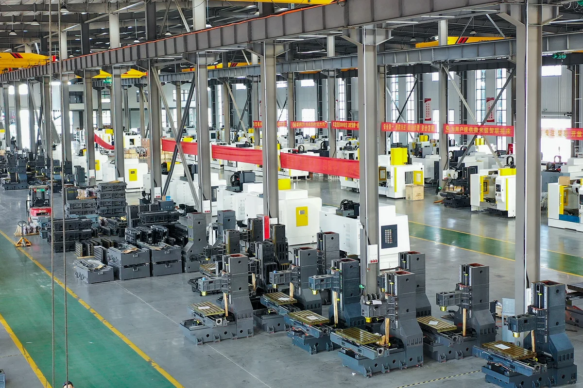 Handemo machine shop floor with rows of CNC lathes and machining centers on a marked aisle